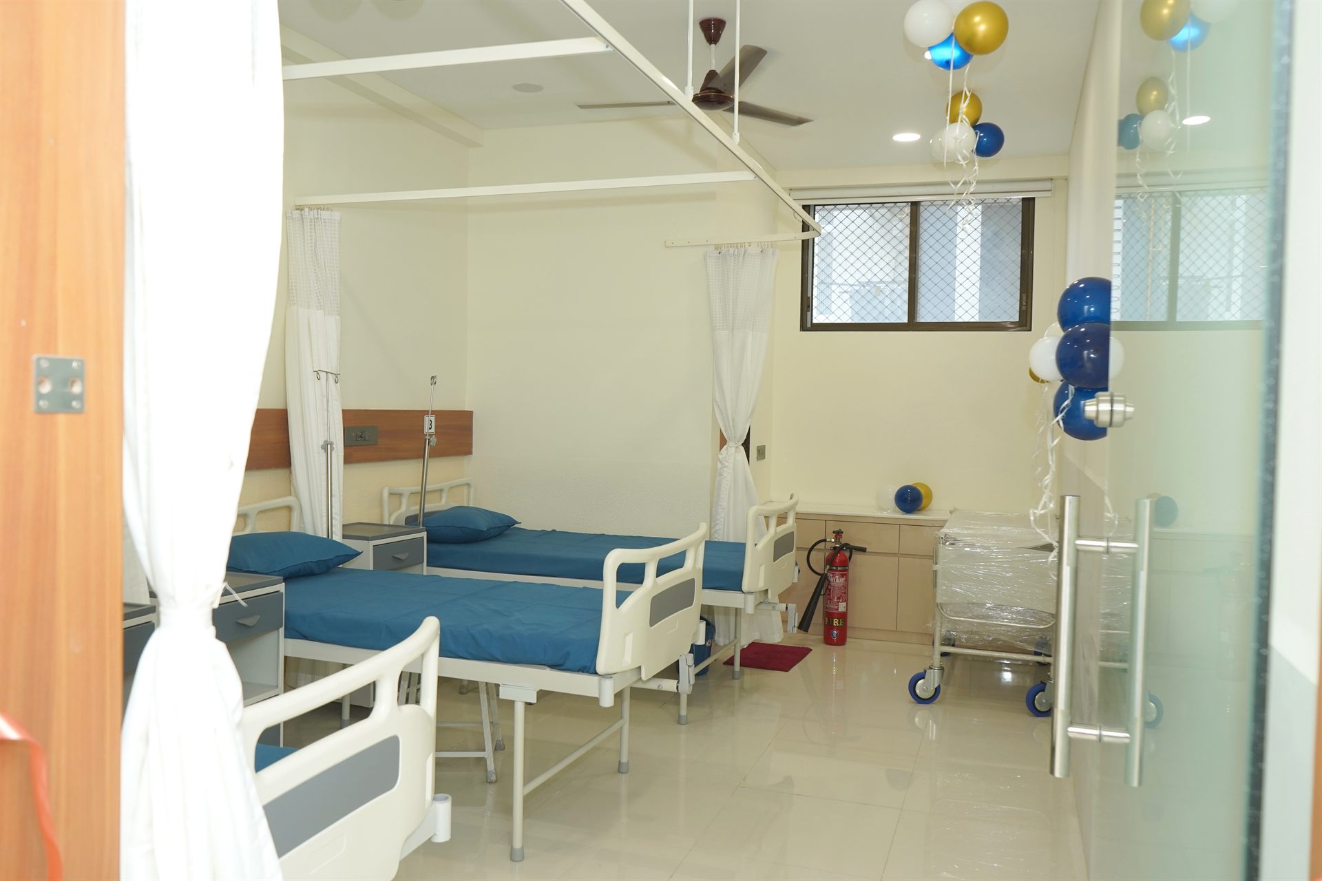 Clean shared patient room with hospital beds at Lotus Hospital